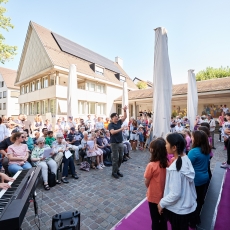 Kinderchor und Dirigent und junges sowie älteres Publikum