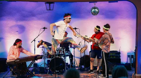 Band spielt auf Bühne und Sänger macht Sprung in die Luft