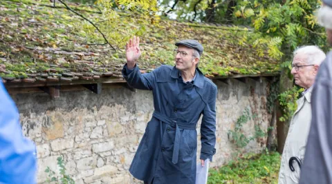 Gästeführender zeigt das alte Waschhaus in Riehen